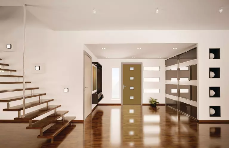 A clean, minimalist modern home with a recently waxed floor and a free-standing set of stairs.