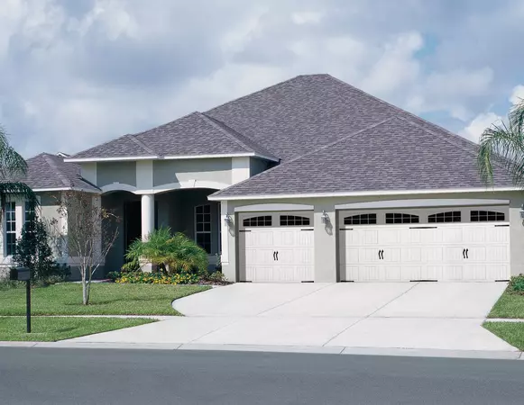 White vertical short panel  garage door with arch stockton windows and decorative hardware