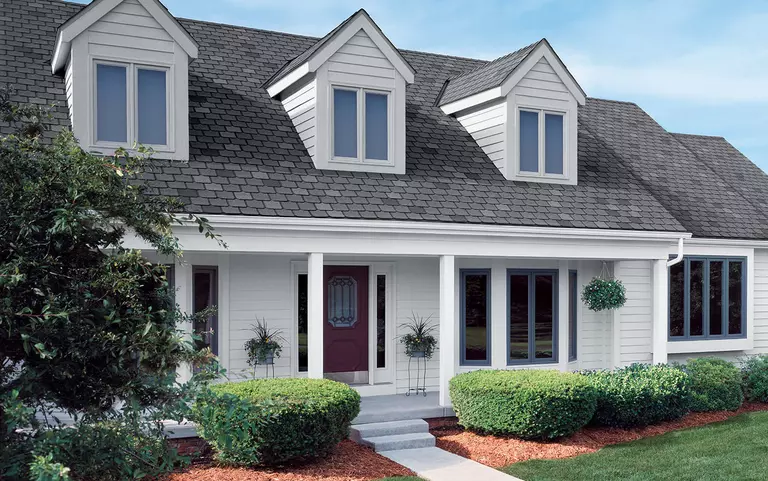 Exterior of a two-story home with multiple window styles and sizes.