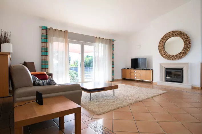 Living room with a tiled floor with patio door window treatments