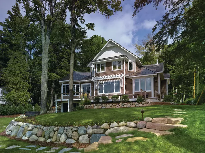 A house with a large front yard and trees all around it