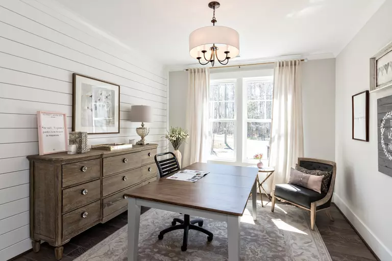 Interior room of a home office with a table and seating.
