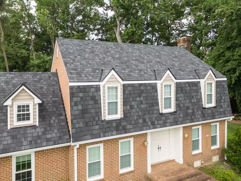 Gambrel style roof with four dormers and a window in each.