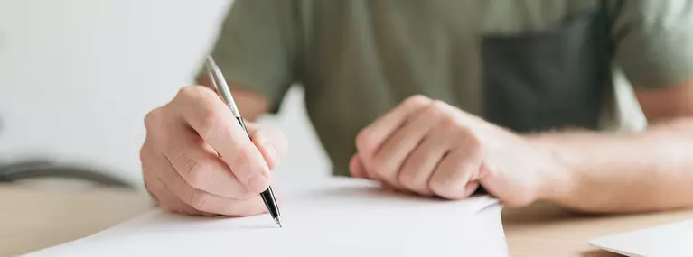 Man writing on an exam paper.
