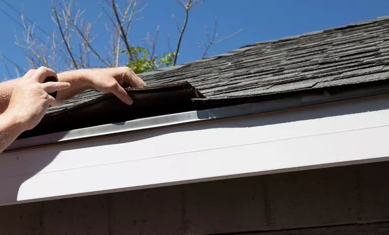 A contractor inspecting the roof and gutters of a home.