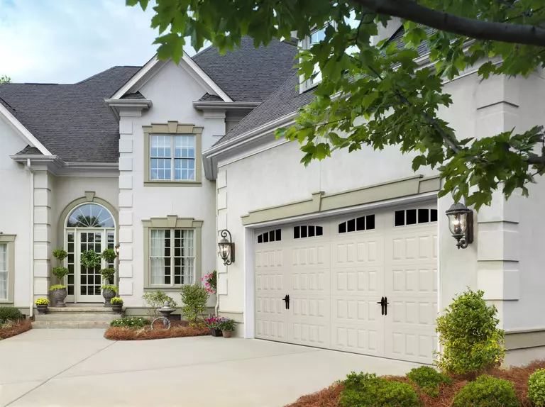 Almond-colored Ammar Hillcrest garage door with arched thames and alpine handles.