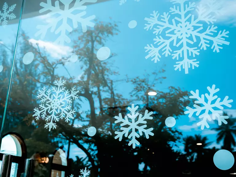 Snowflake decorations on the glass of a commercial window.
