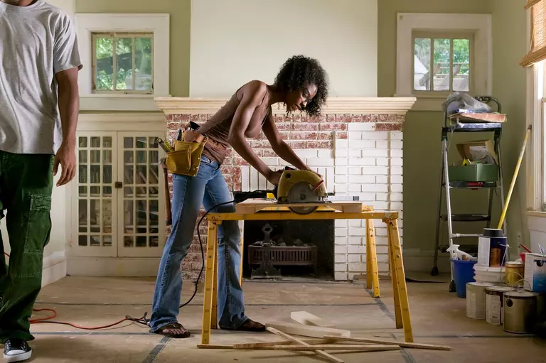 A woman carrying out a DIY home renovation herself instead of hiring contractors to do the work.