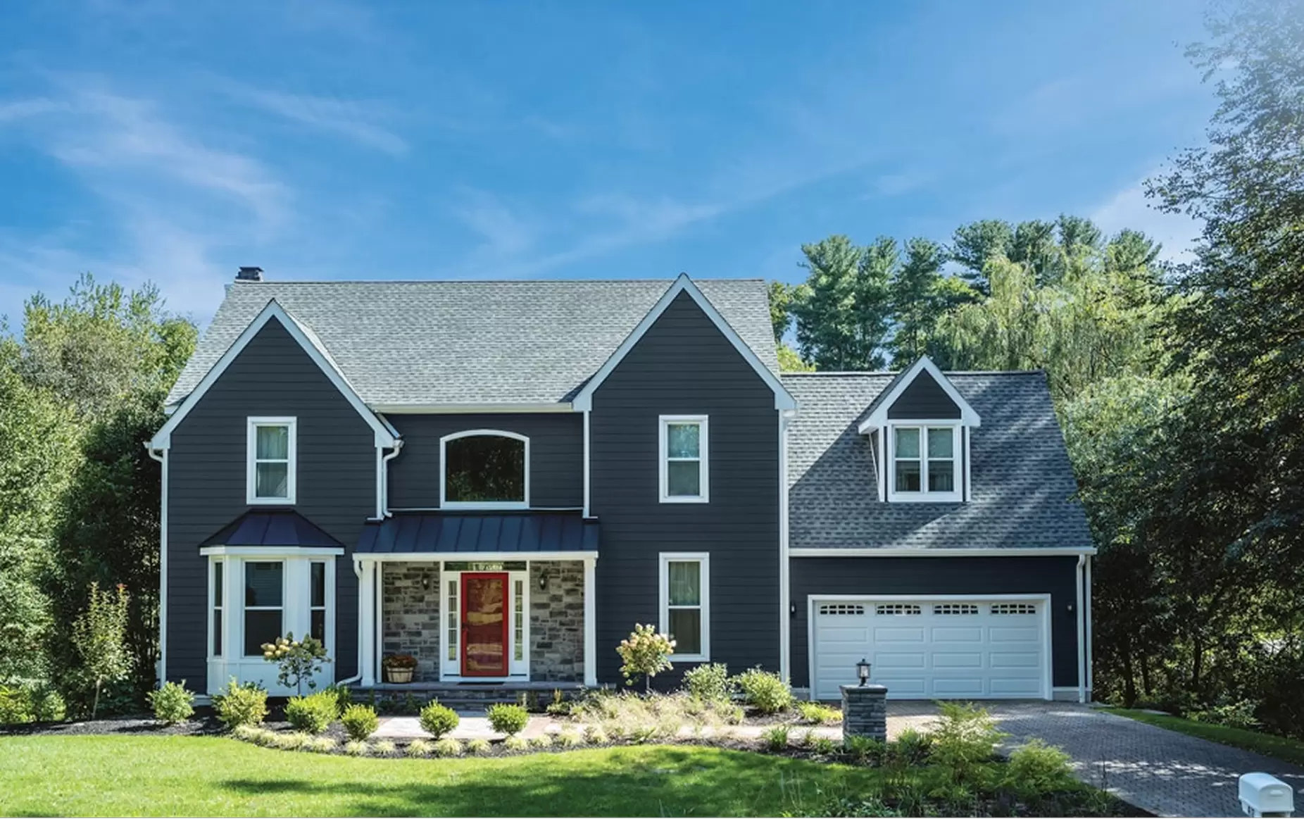 Two-story home with large windows and attached garage.