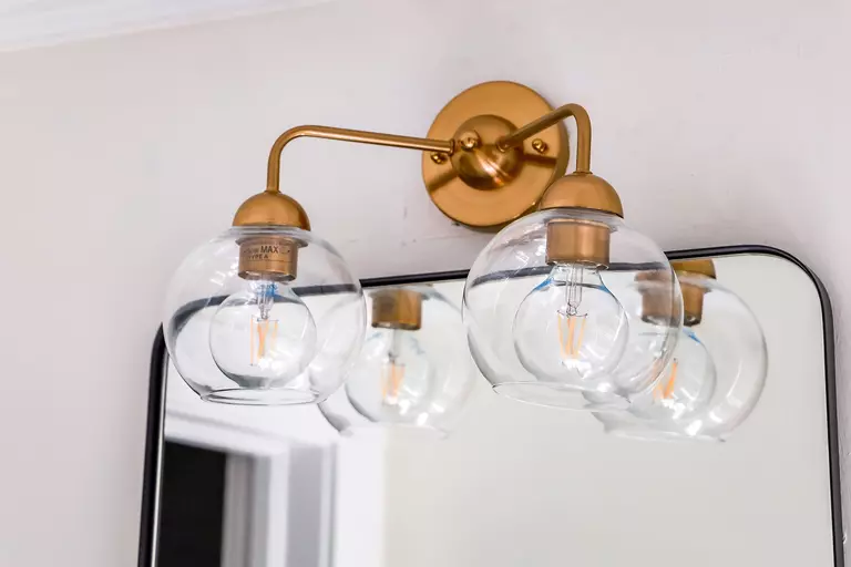 Close-up of bathroom lights above a mirror.