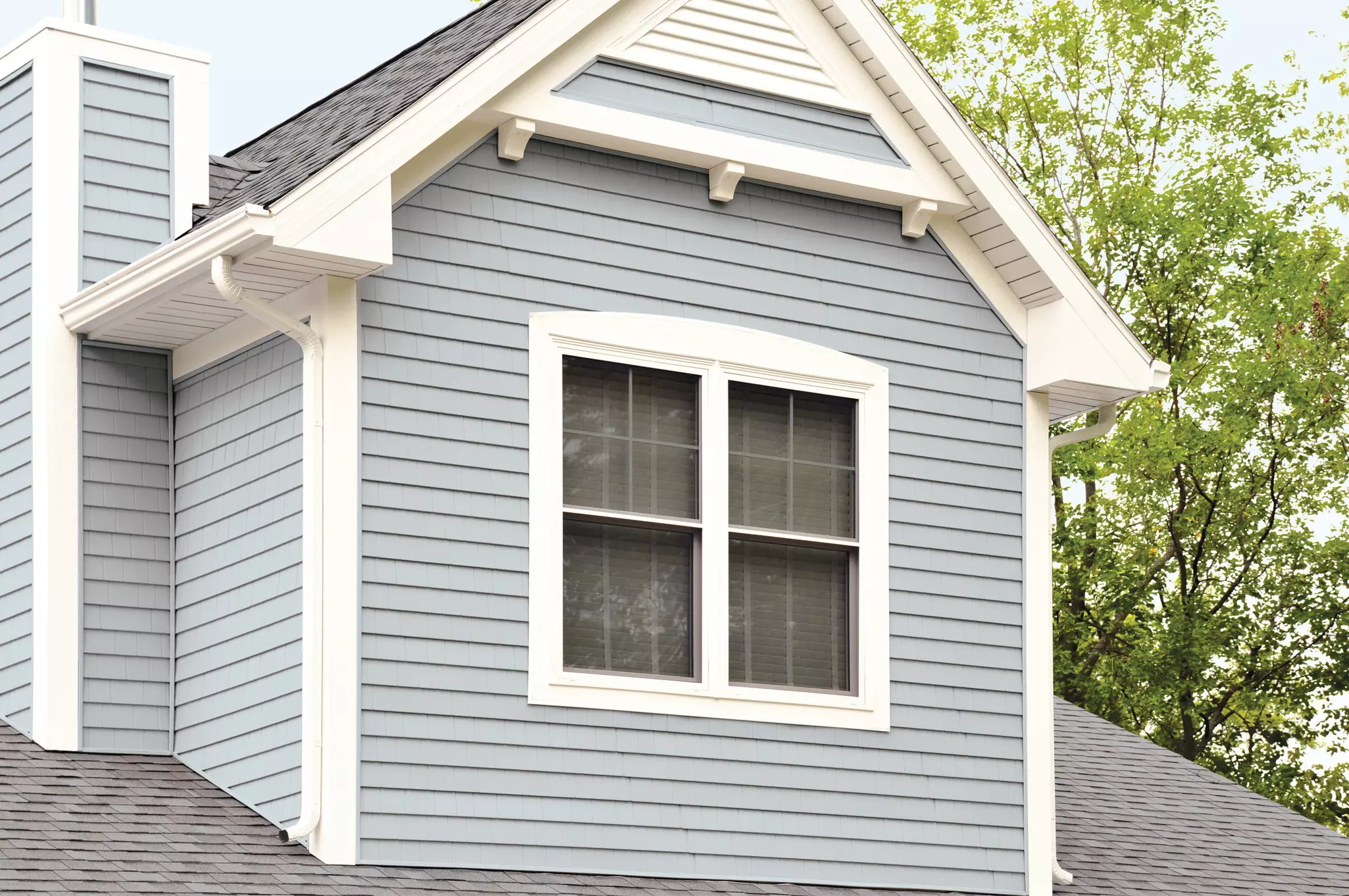 Upper story of a home with light-blue siding.