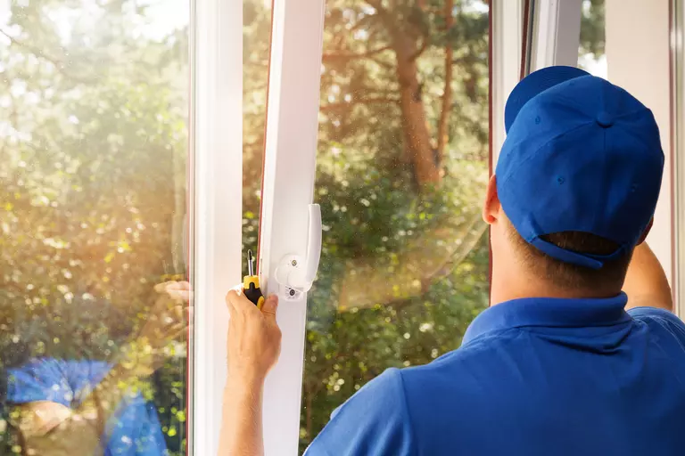 Worker installing new plastic PVC window.