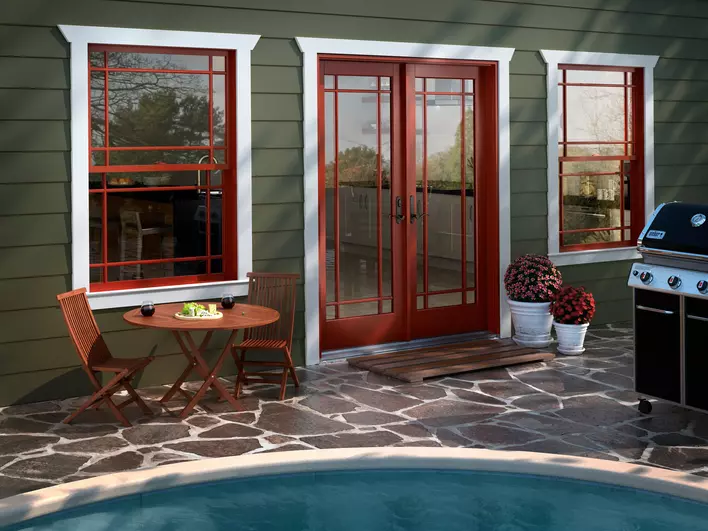 A table and chairs on a patio beside prairie-grid hinged patio doors