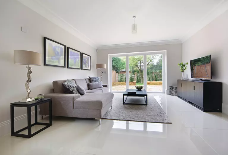 Living room of home with a gray couch, rug, and sliding patio door.