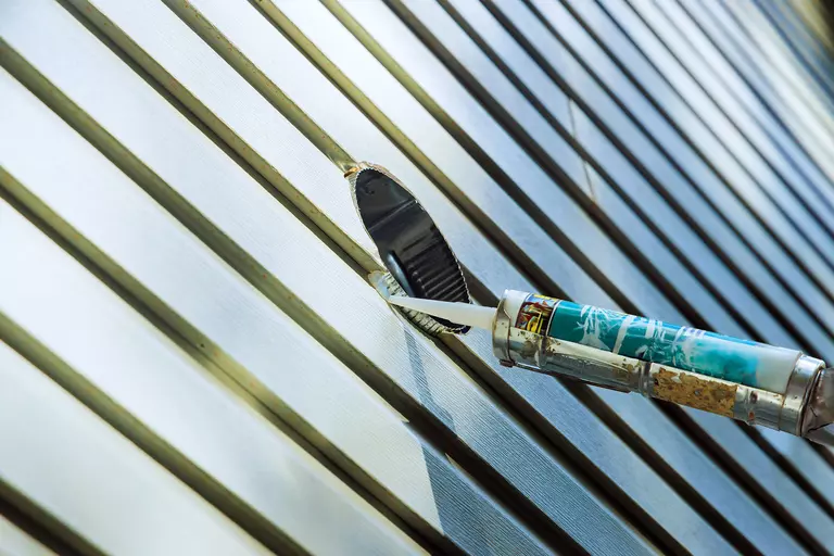 Close-up of caulking of vinyl siding on a home.