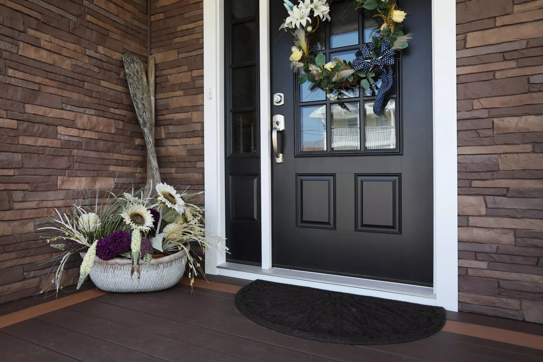 Black entry door with glass panels, a sidelite, and coordinated handle hardware.