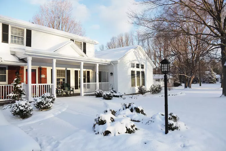 Front yard of a home covered in snow.
