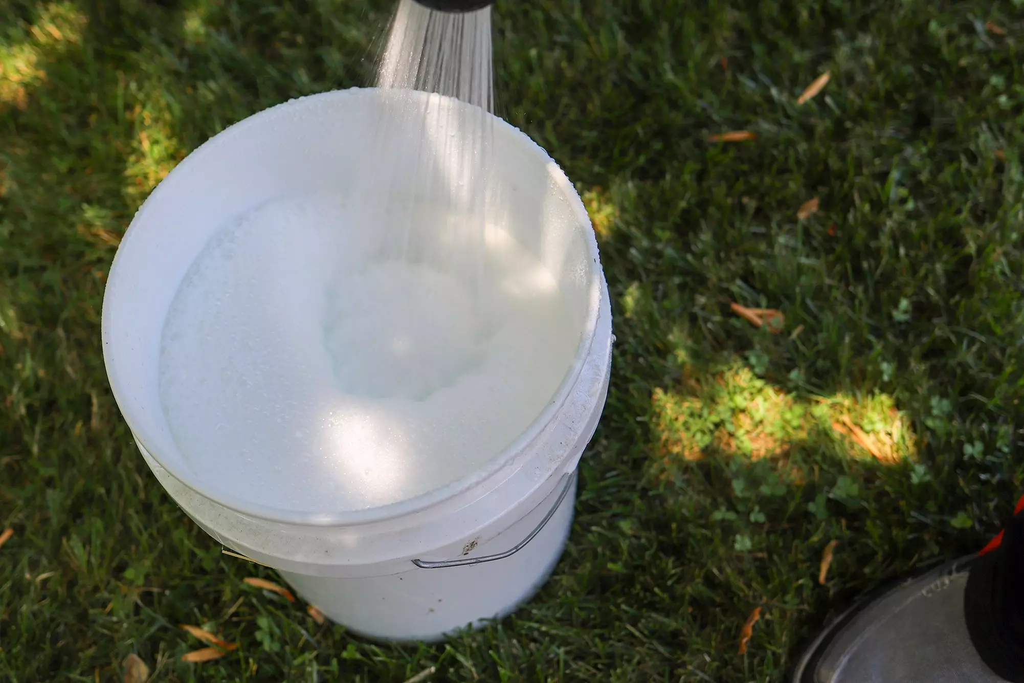 Soap and water being mixed in a bucket in order to clean gutters.