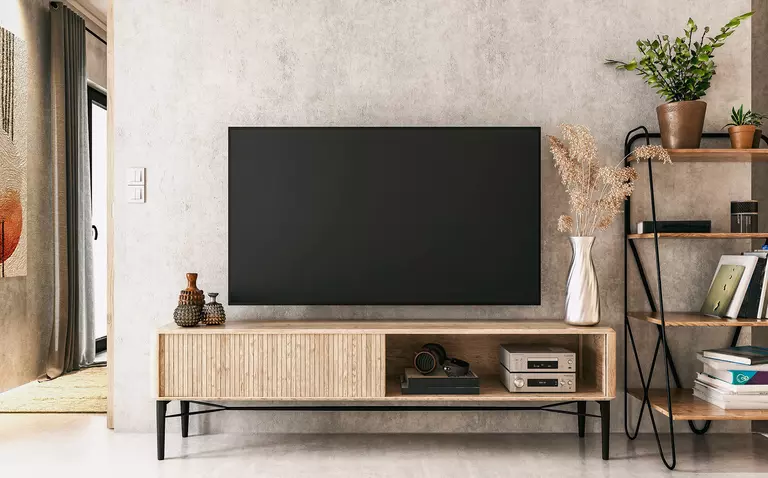 A flat-screen TV in a modern living room. The TV is off, helping to keep the power bill lower and to keep the home from heating up due to the energy expenditure.