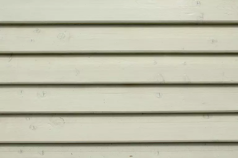 Close-up of white siding boards that look like wood.