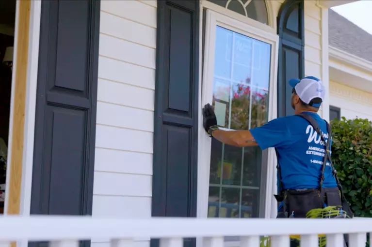 Window World installation professional setting a white window into a home.